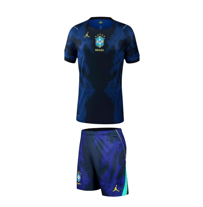 Camisa de criança Velukz Brasil 2026, uniforme alternativa away, azul com detalhes em amarelo e verde, vista frontal.