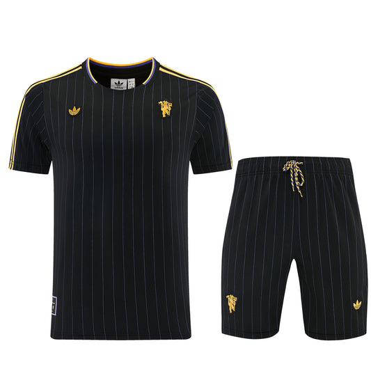 Conjunto Velukz LifeStyle Manchester United com camisola e calças pretas, detalhes do clube e logotipo visíveis.