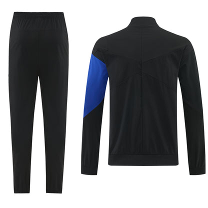 Fato de treino Velukz Chelsea 26/27, conjunto de roupa esportiva, com calças e jaqueta, em cores preto e branco, para atividades físicas.