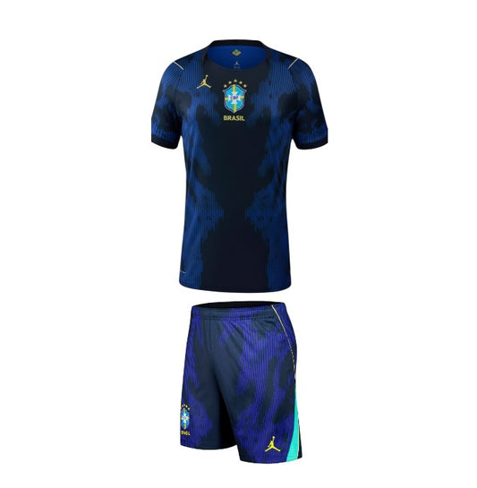 Camisa de criança Velukz Brasil 2026, uniforme alternativa away, azul com detalhes em amarelo e verde, vista frontal.